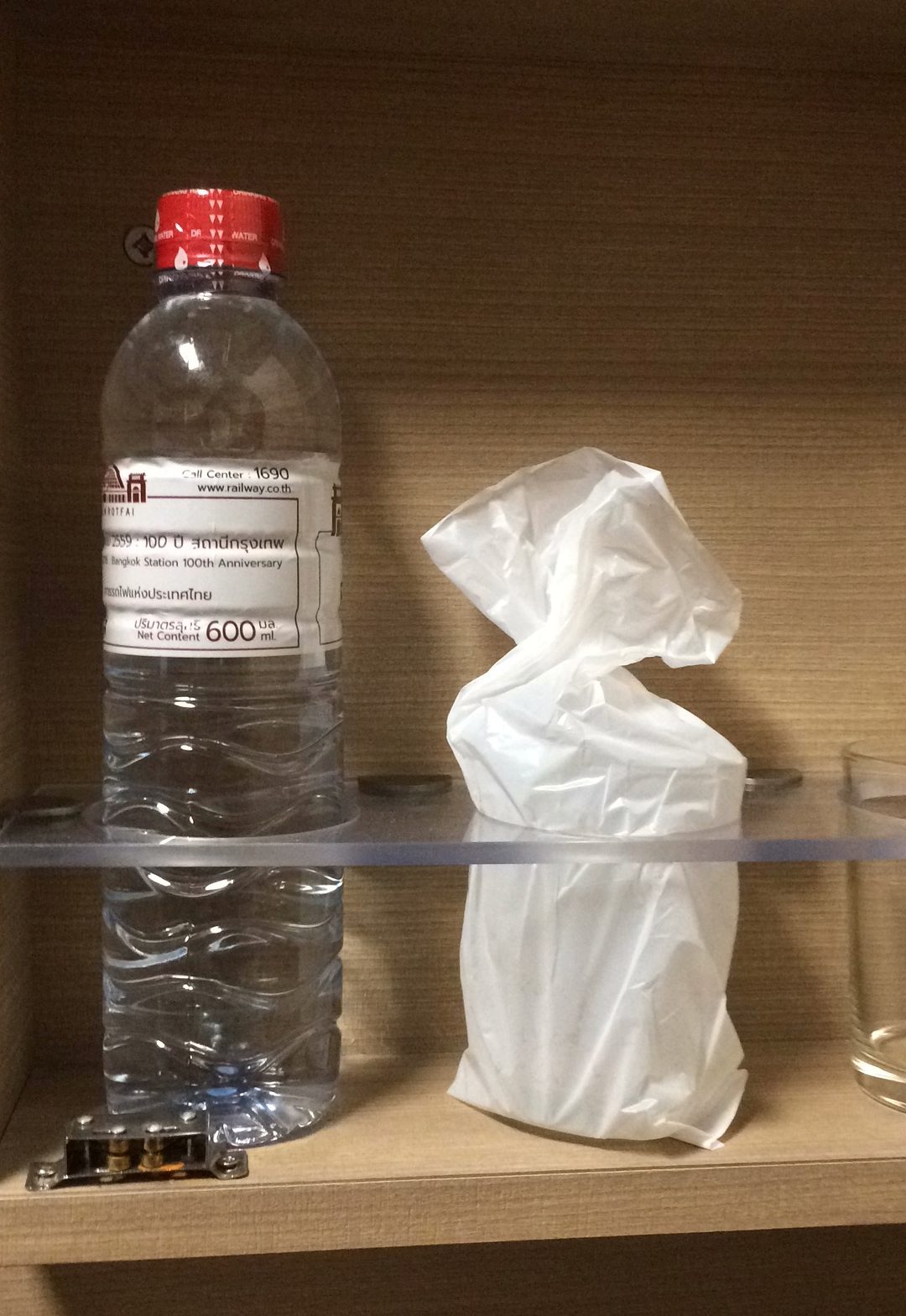 a plastic bottle and a tissue paper bag on a shelf