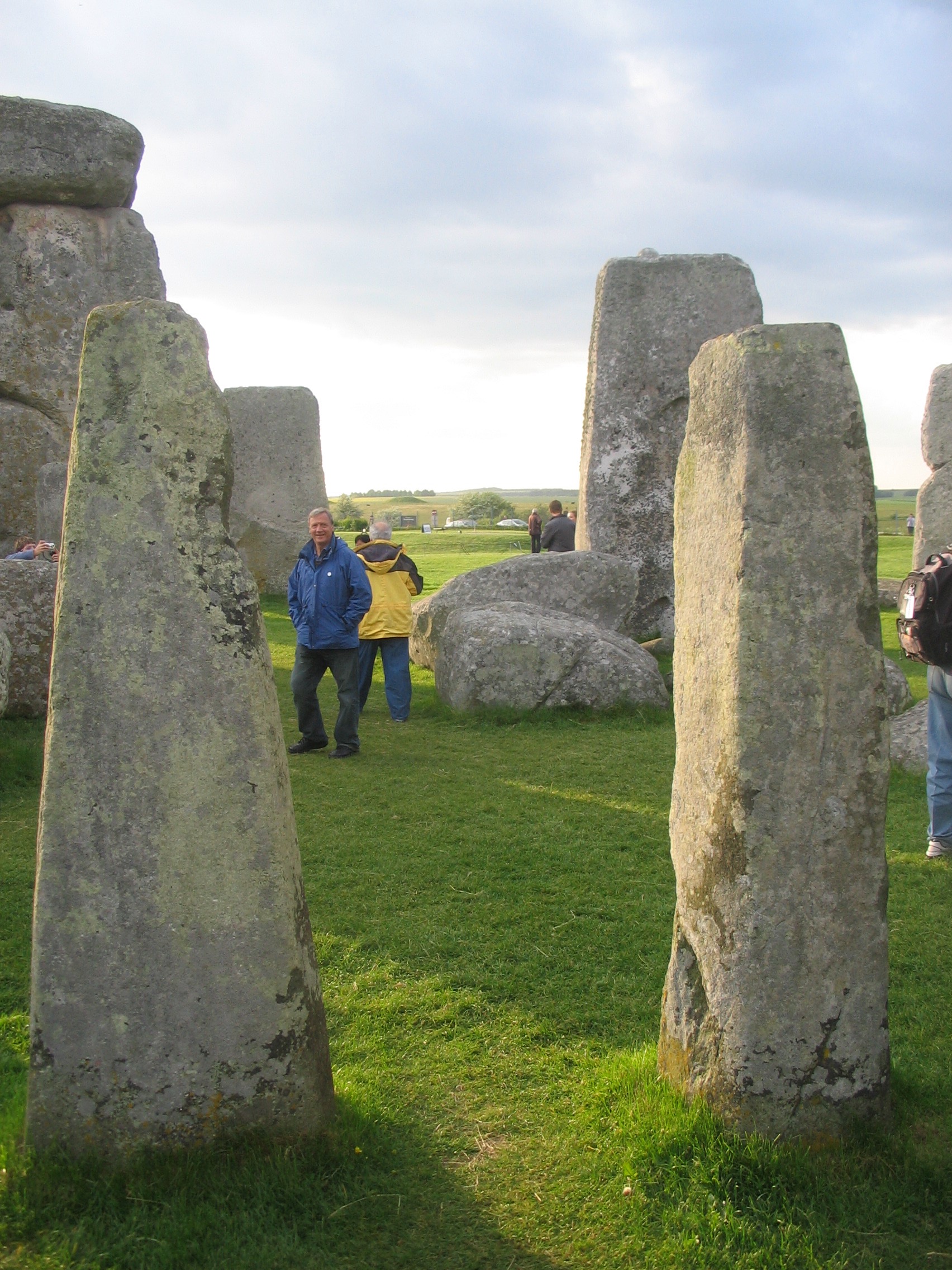 a group of people standing in a grassy area with large stones
