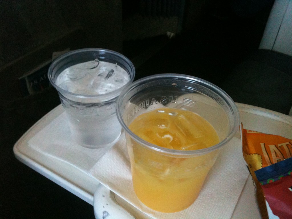 two plastic cups of liquid and a napkin on a tray