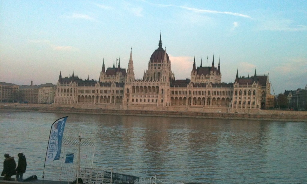 a large building with towers and a large dome on the side of it with Hungarian Parliament Building in the background
