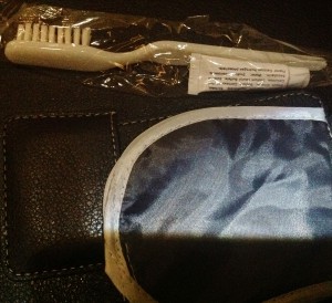 a toothbrush and eye mask on a leather surface