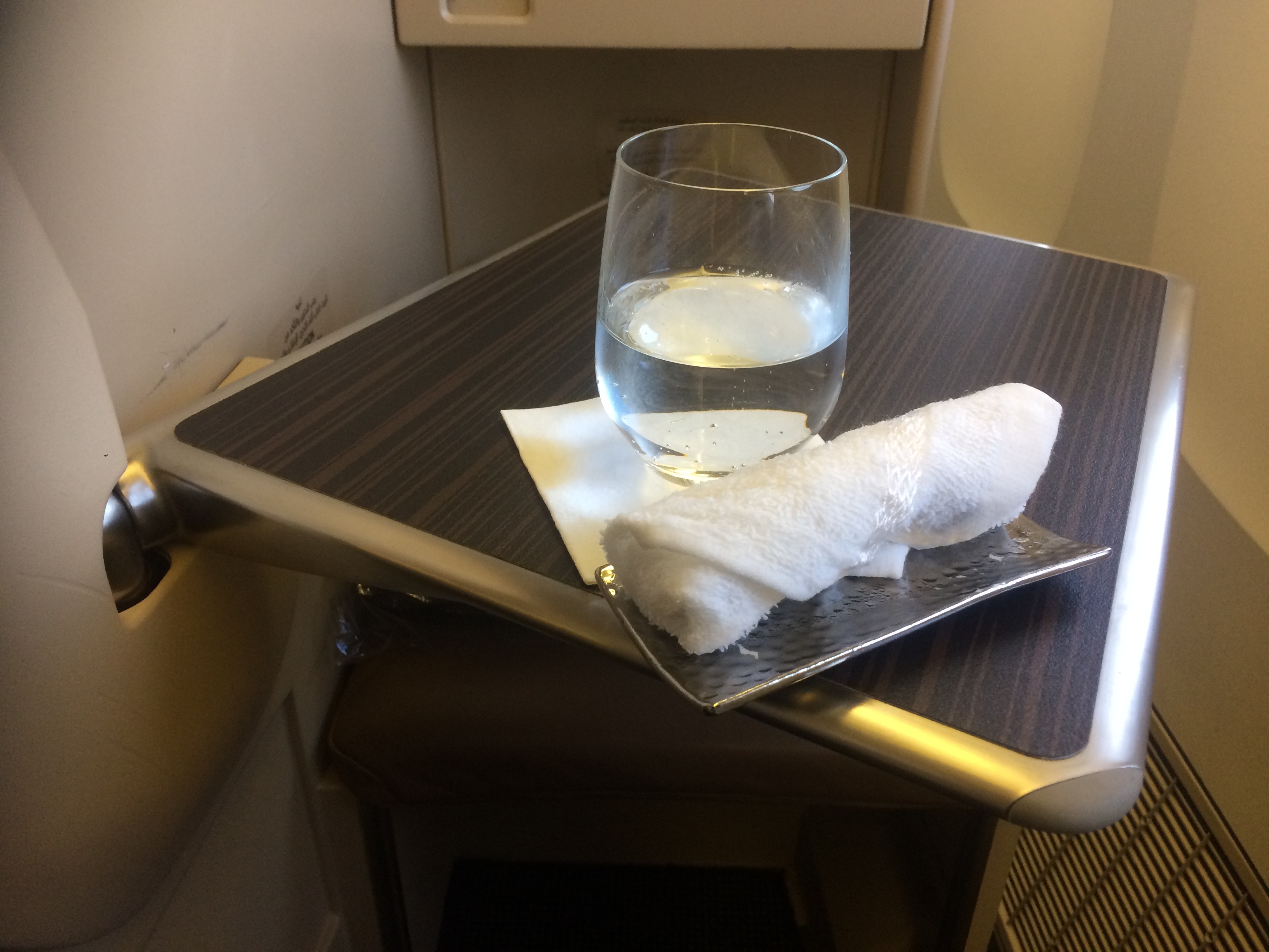 a glass of water and a towel on a tray