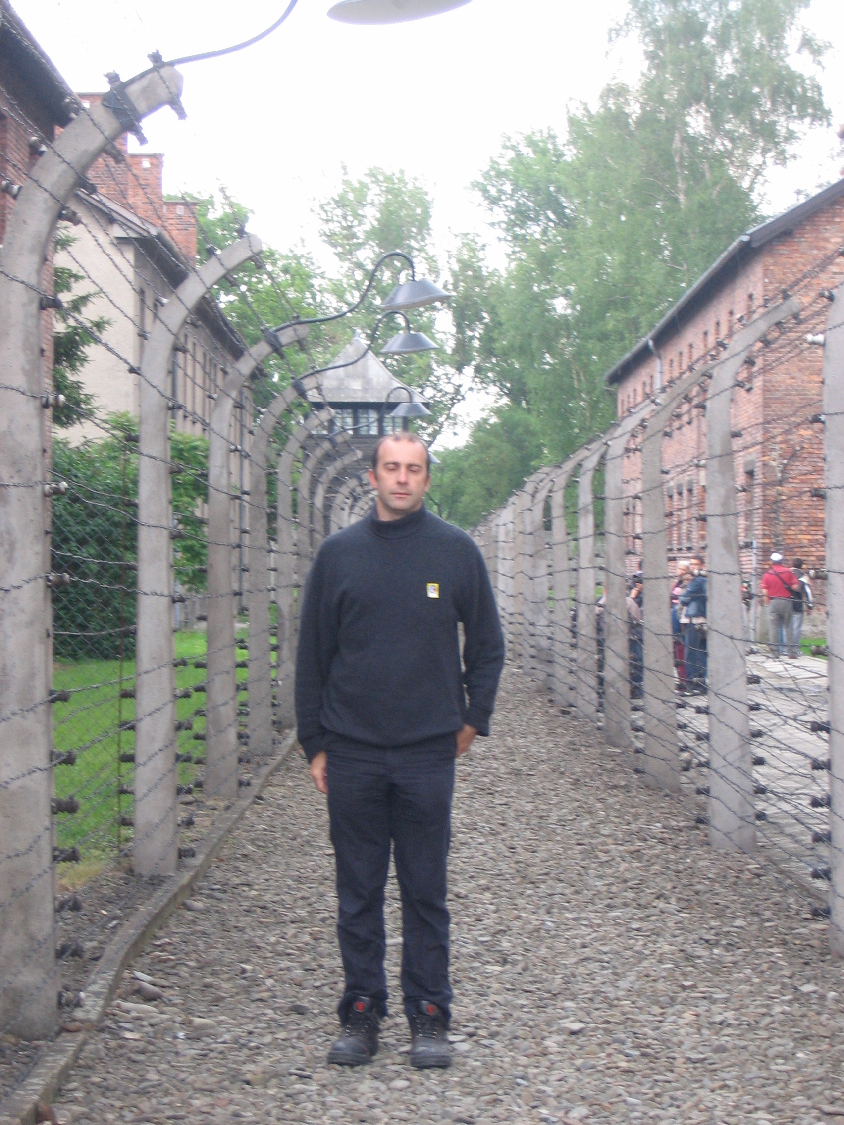 a man standing in a row of barbed wire fence