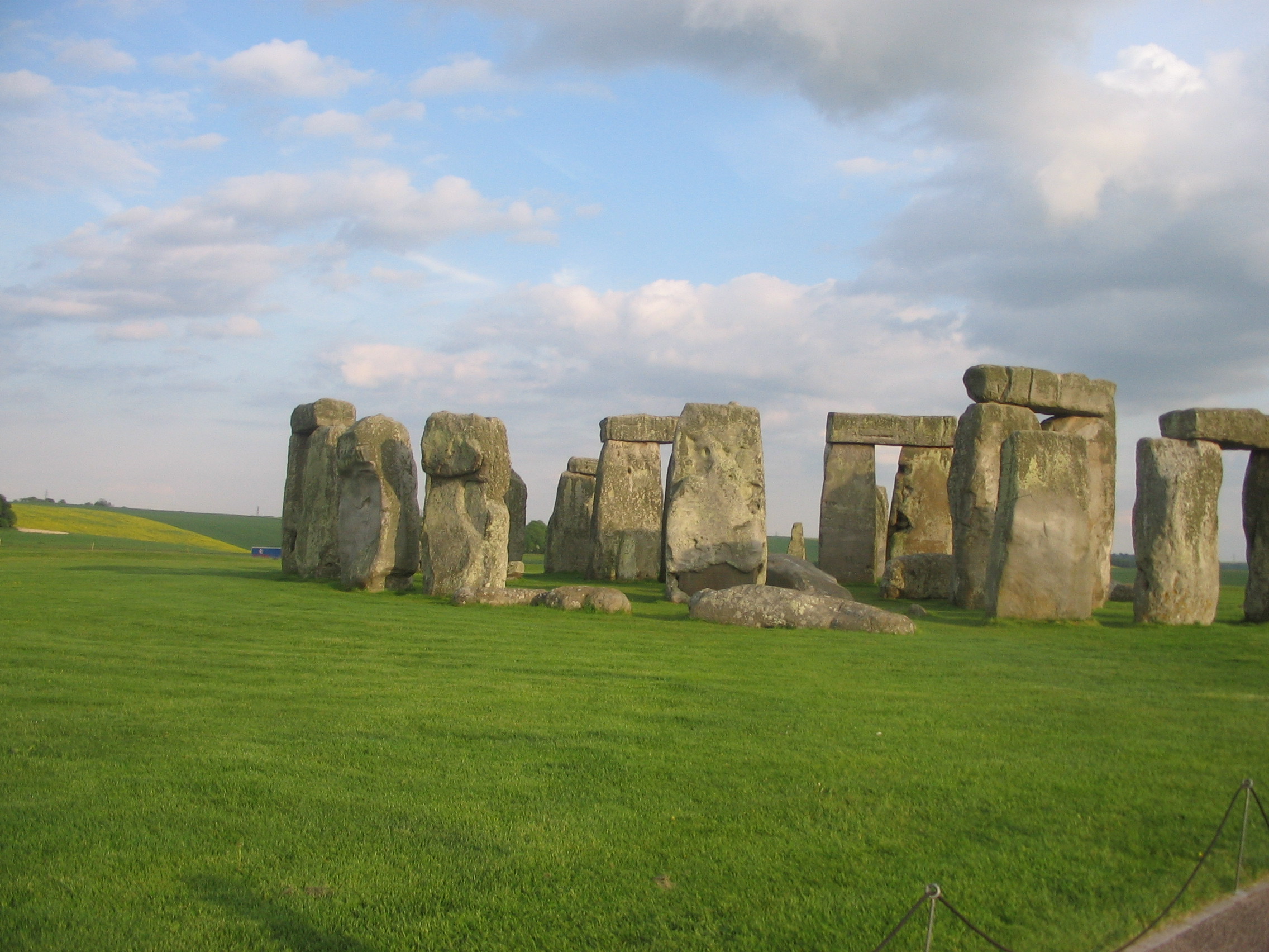 a stonehenge in a grassy field with Stonehenge in the background