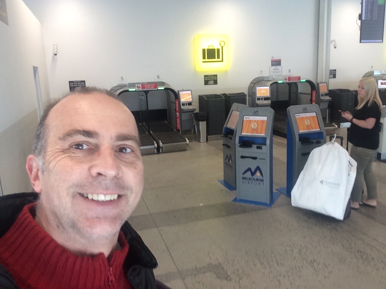 a man taking a selfie in front of a check-in counter