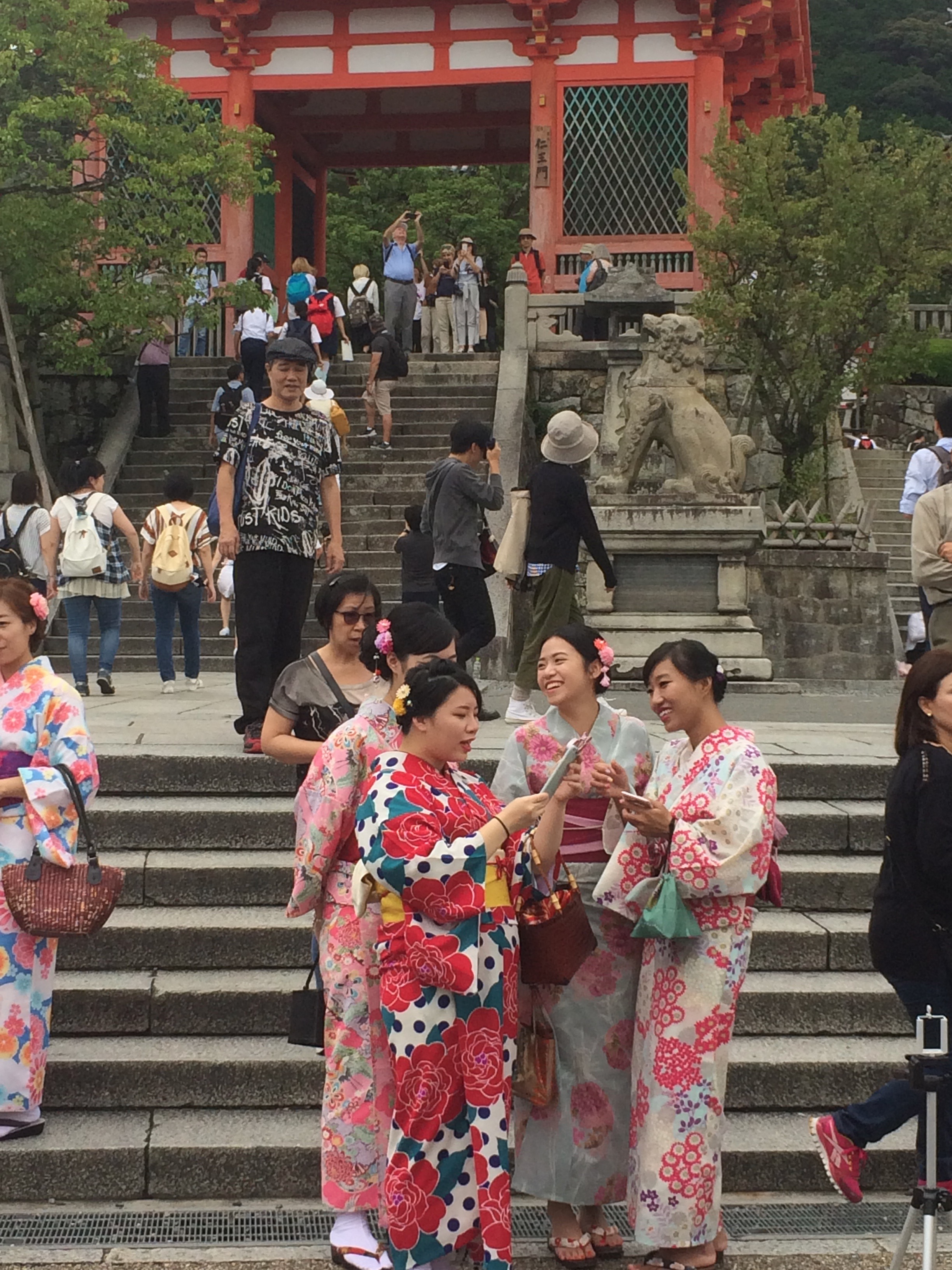a group of women in kimonos standing on stairs