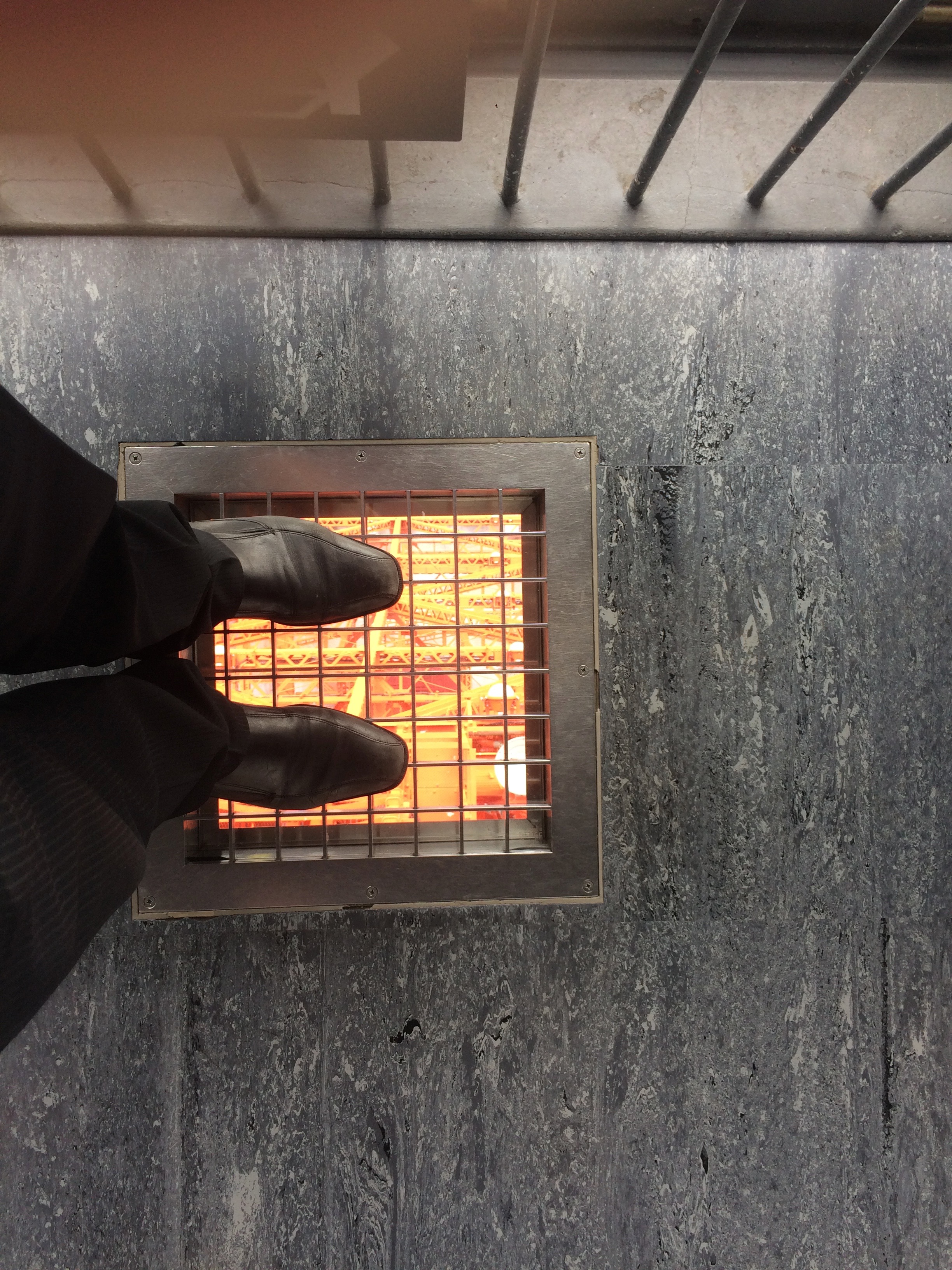a person's feet in a metal grate with fire