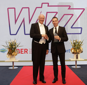 two men in suits on a red carpet