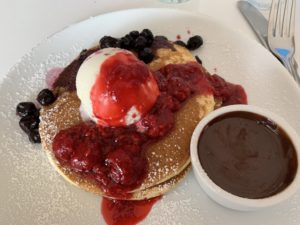 a plate of pancakes with ice cream and fruit