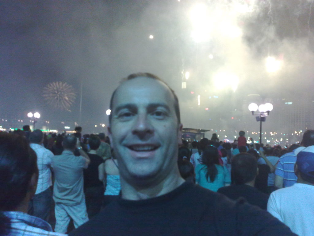 a man taking a selfie with fireworks behind him