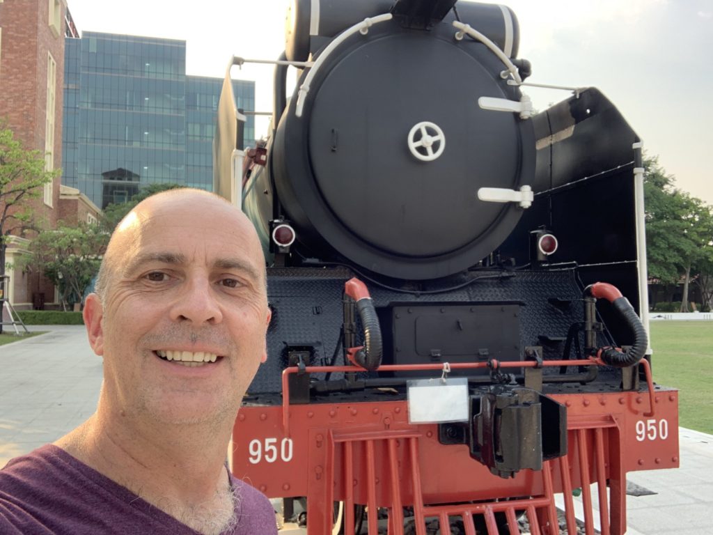 a man taking a selfie in front of a train