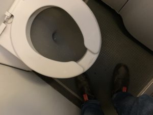 a person's feet in a toilet