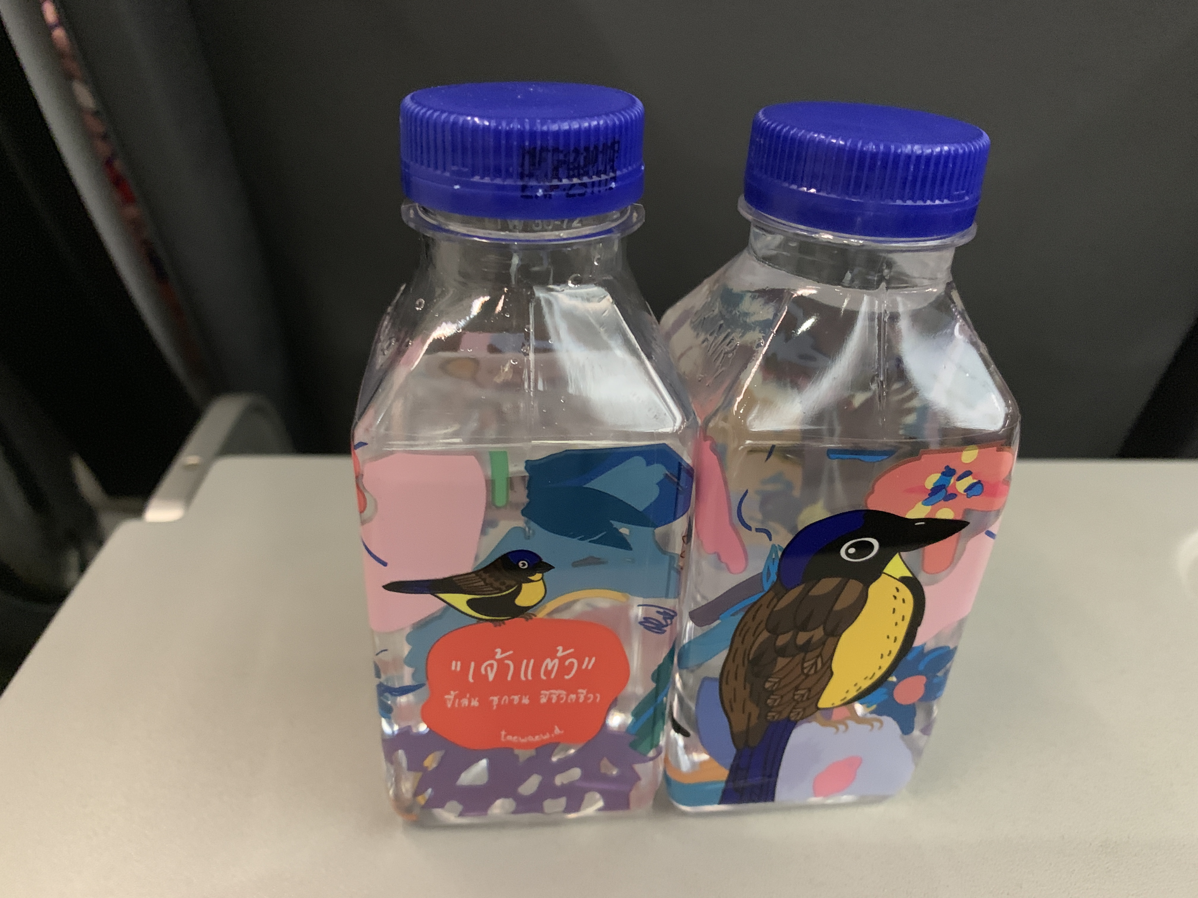 two plastic bottles with colorful designs