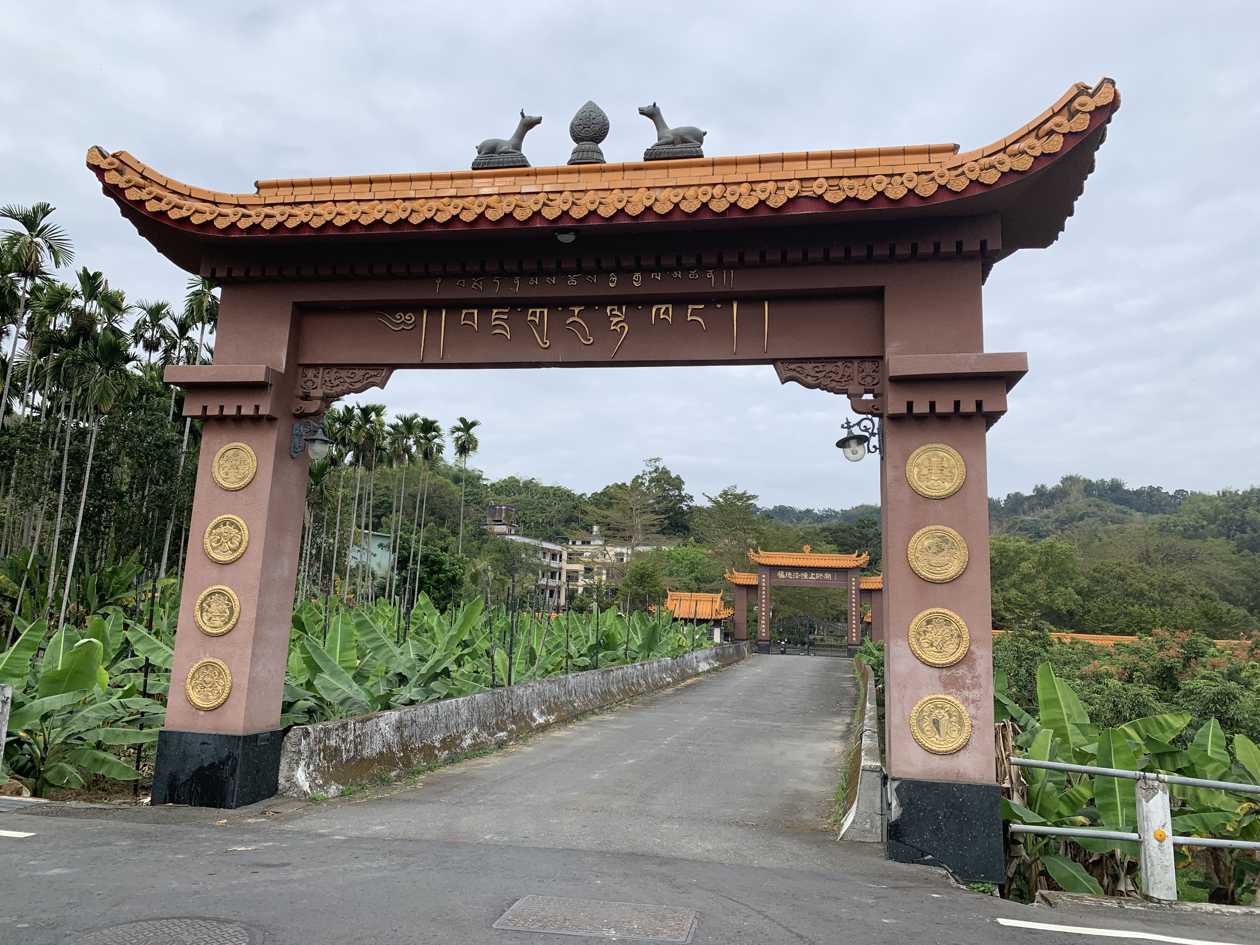 a gate with a red roof and a couple of animals on top