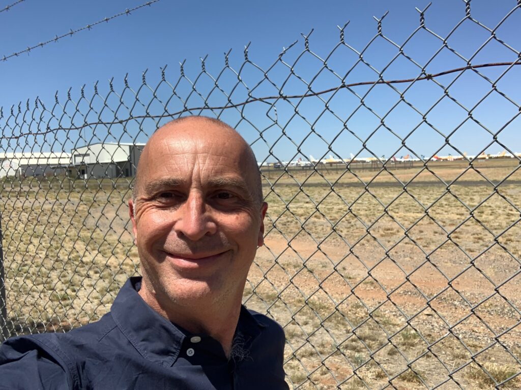 a man standing in front of a fence