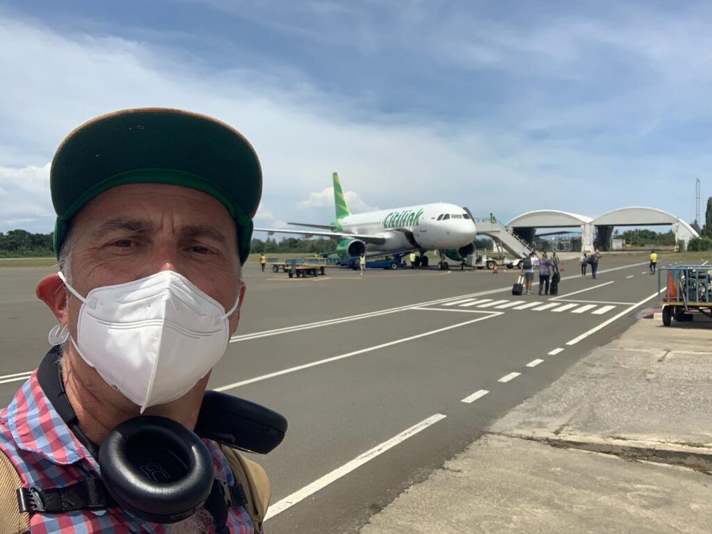 a man wearing a face mask and a plane in the background