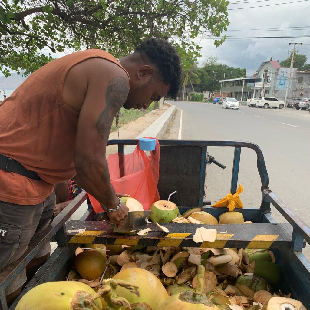 a man cutting coconuts on a cart