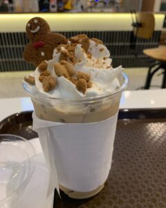 a cup of iced coffee with gingerbread man on top