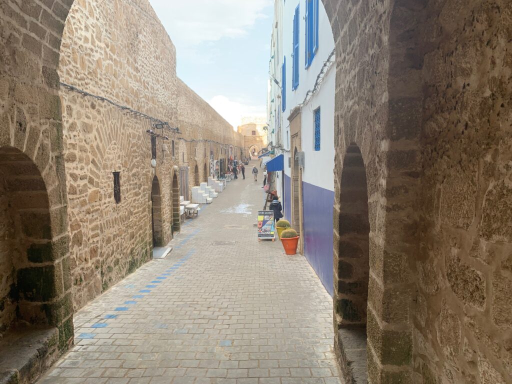 a stone alleyway with people walking on it