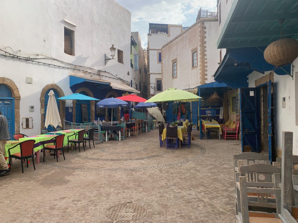 a courtyard with tables and umbrellas