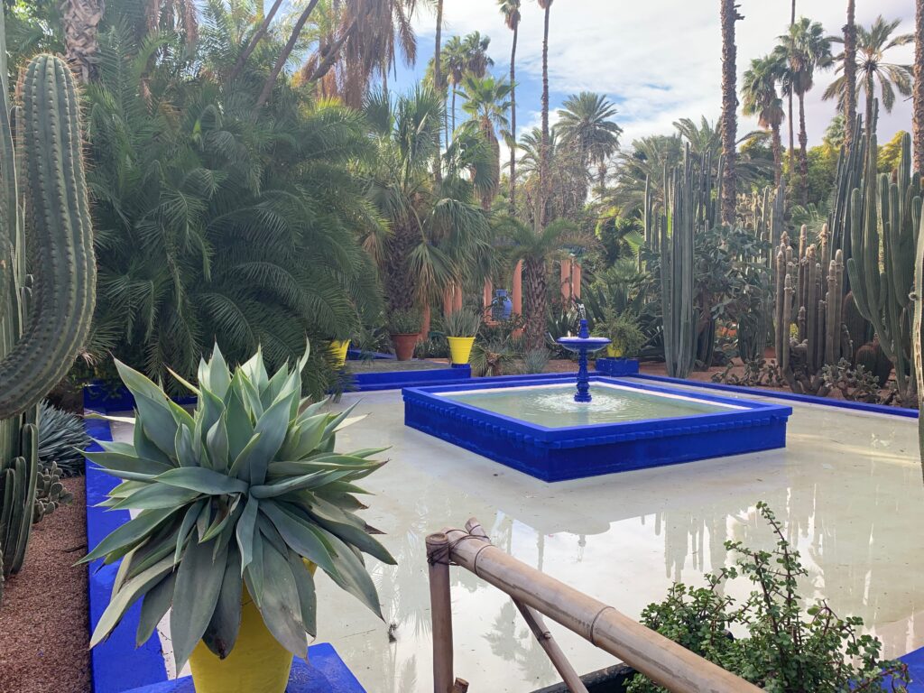 a blue fountain surrounded by palm trees