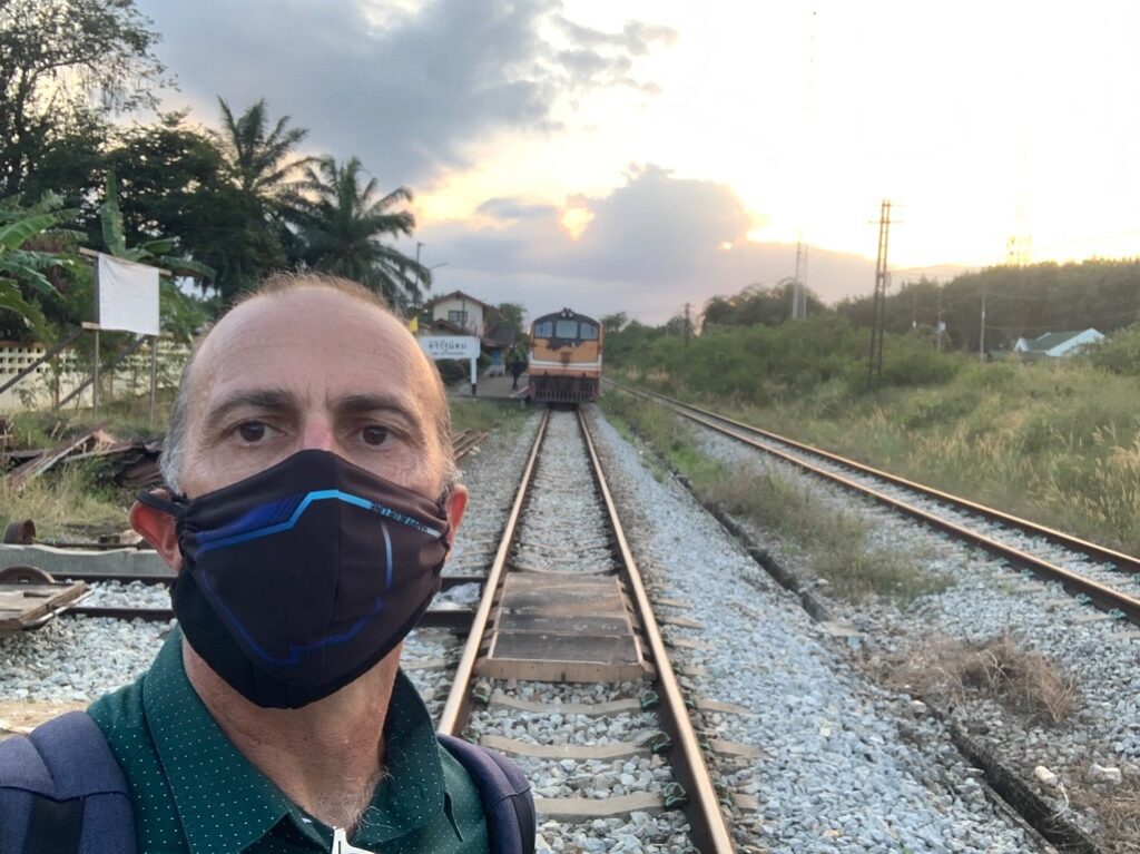 a man wearing a face mask on train tracks