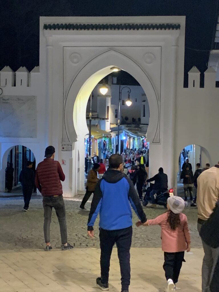 a group of people walking through a white archway
