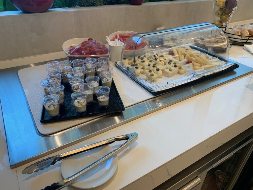 a buffet table with food in plastic cups