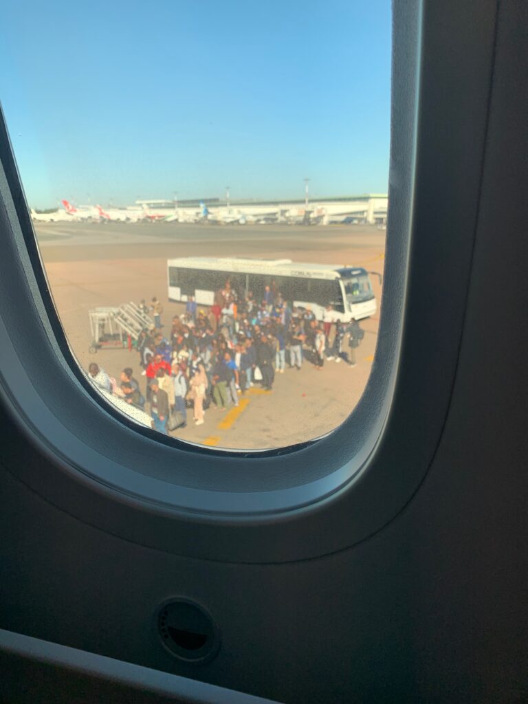 a group of people standing outside of an airplane window
