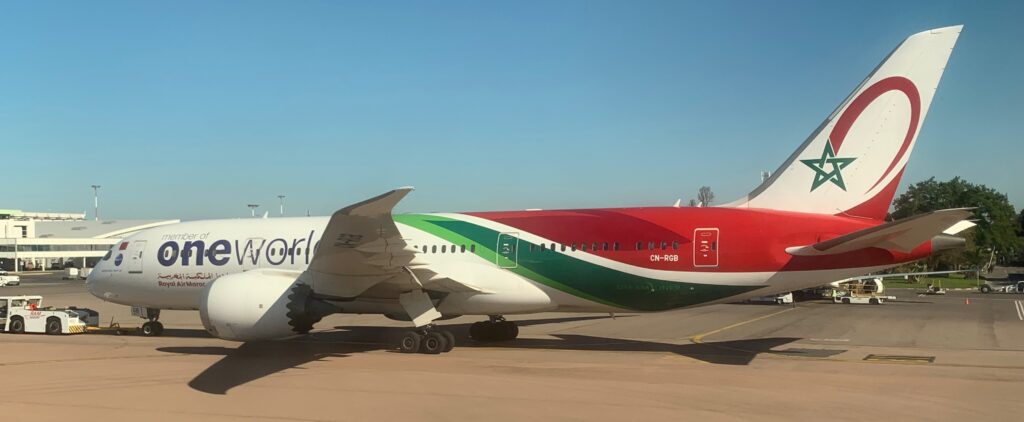 a red and green airplane on a runway