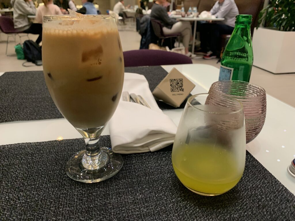 a glass of liquid and a bottle of liquid on a table