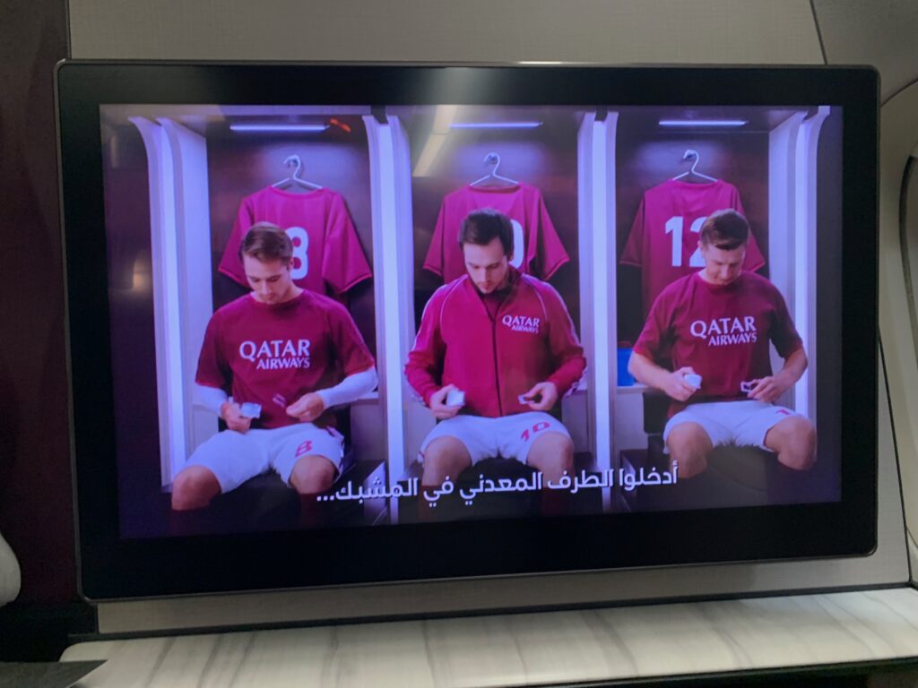 a television screen showing a group of men sitting in lockers