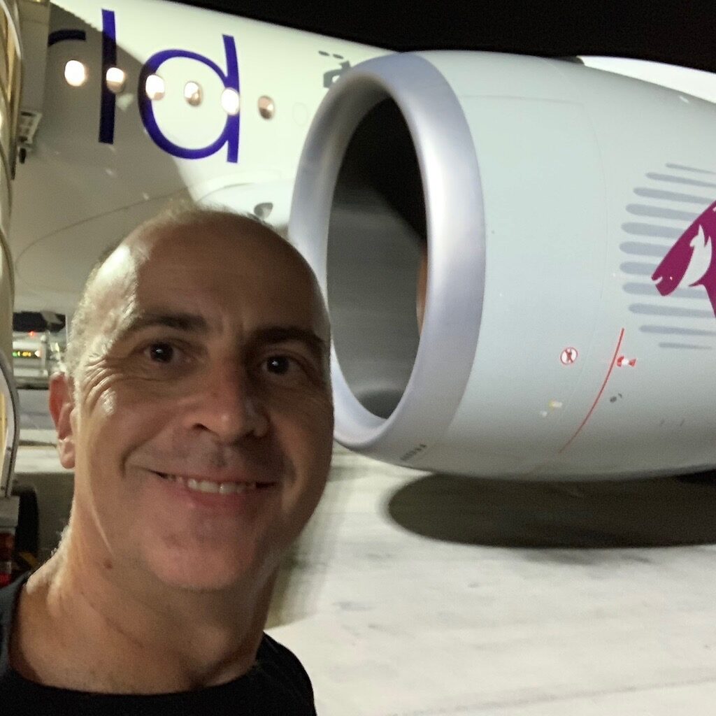 a man taking a selfie in front of a jet engine