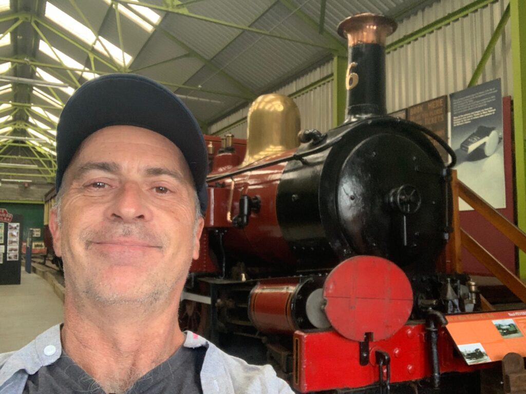 a man taking a selfie in a train museum
