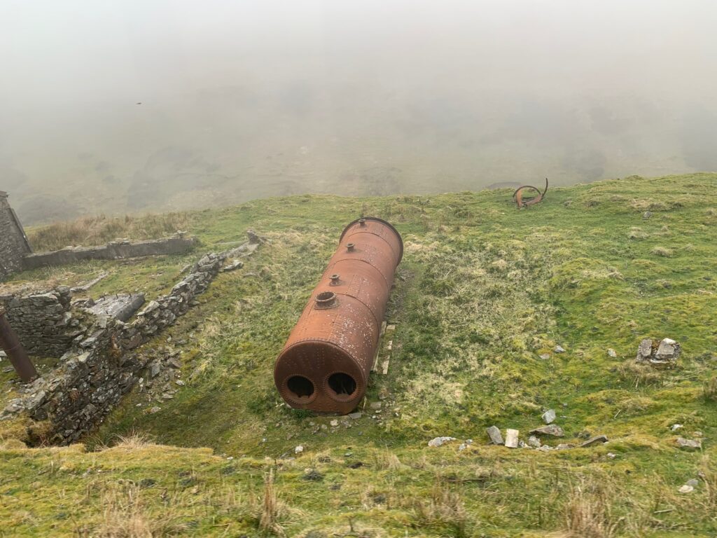 a large metal cylinder on a grassy hill