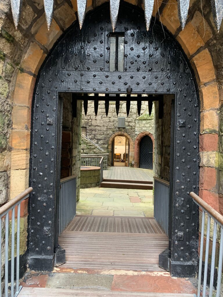 a stone archway with a metal gate
