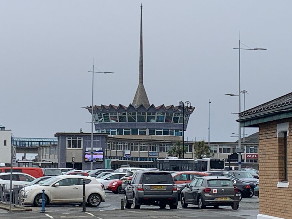 a parking lot with a tower and cars
