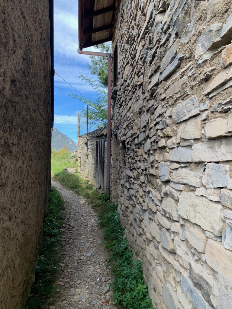 a stone wall with a path between buildings
