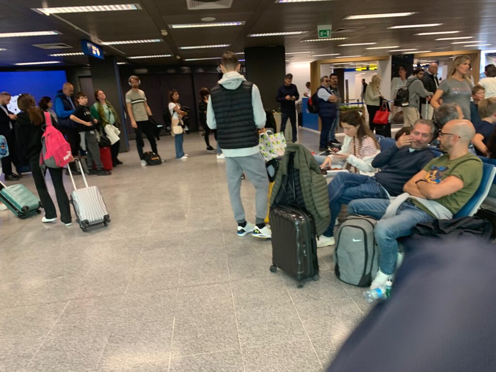 a group of people in a room with luggage