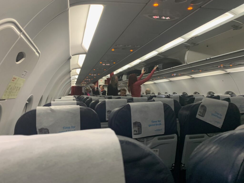 people in an airplane with people standing in the back