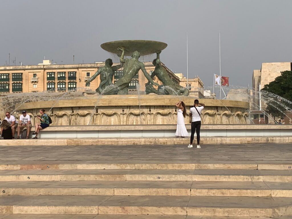 a group of people taking a picture of a fountain