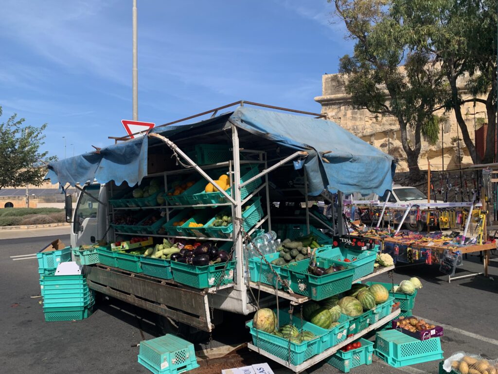 a food truck with many baskets of vegetables