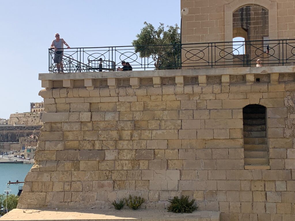 a man standing on a railing on a stone wall