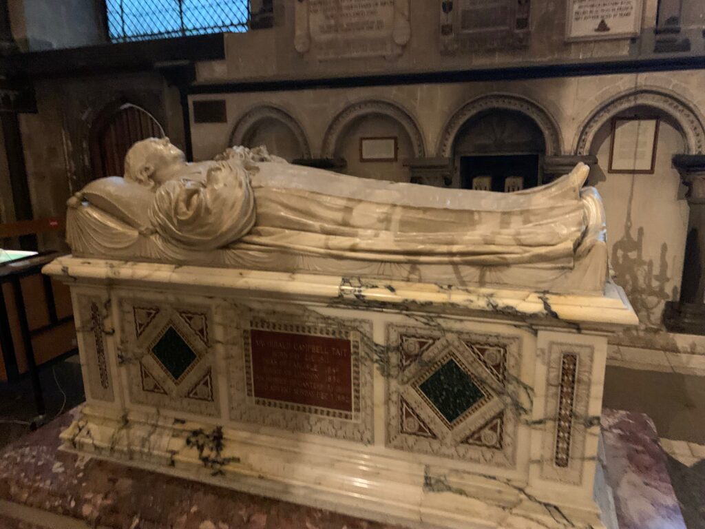 a statue of a man lying on a marble base