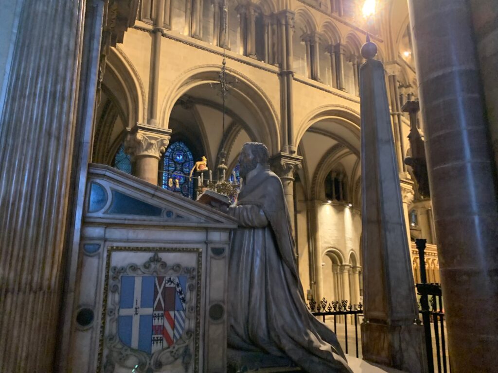 a statue of a man in a robe standing at a podium in a church