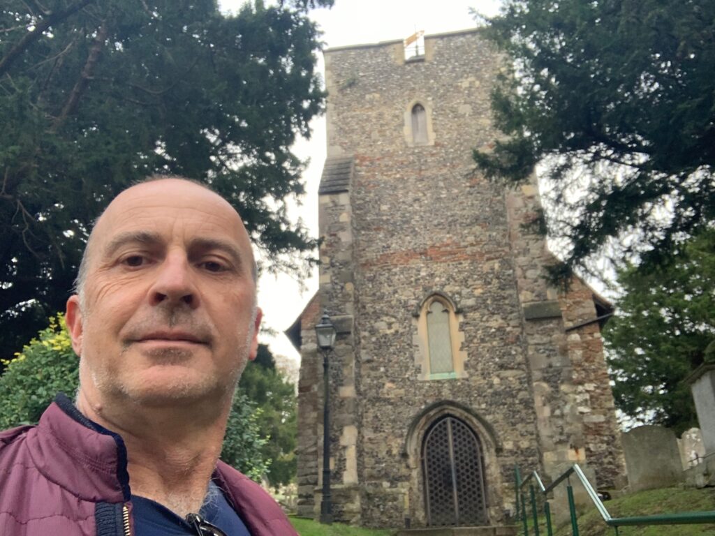 a man taking a selfie in front of a stone building