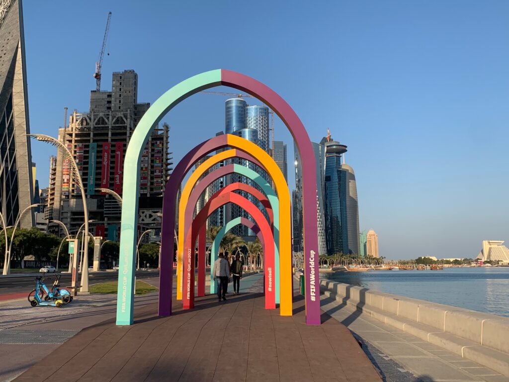 a colorful archways on a walkway by a body of water