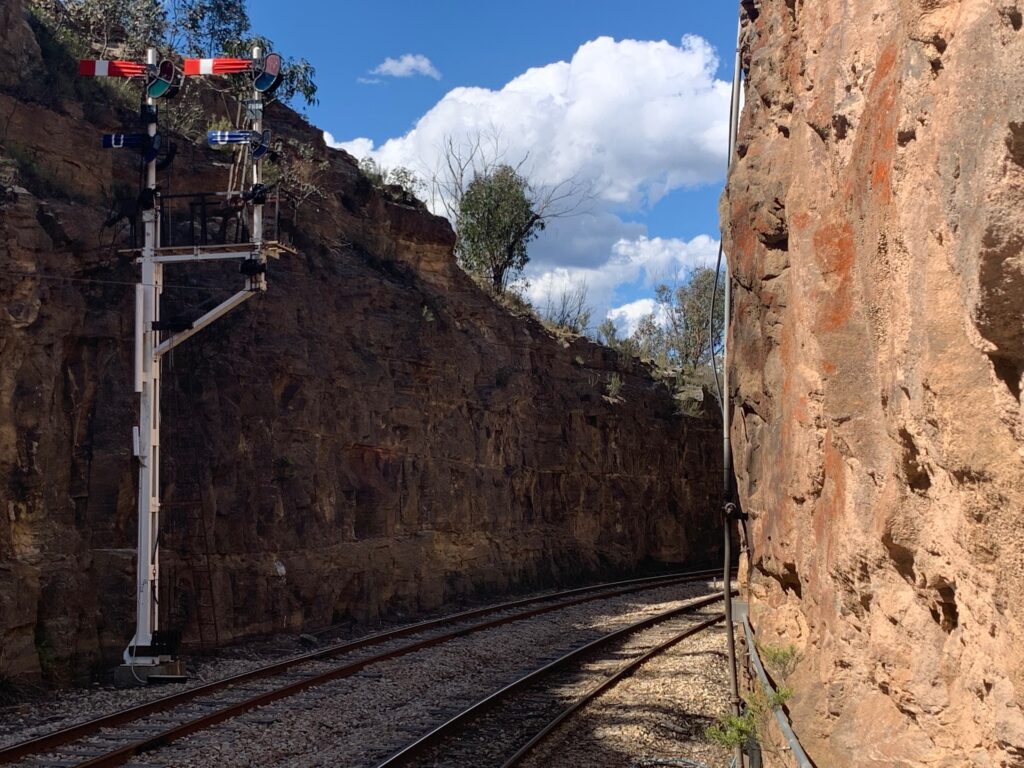 a train tracks next to a cliff