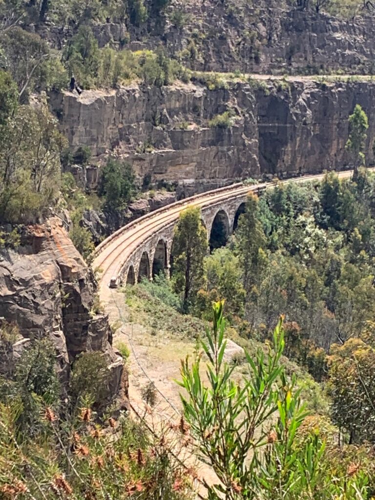 a train track with a bridge over a cliff