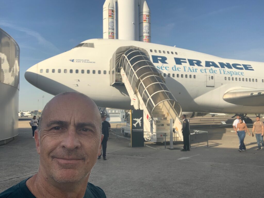 a man taking a selfie in front of a plane